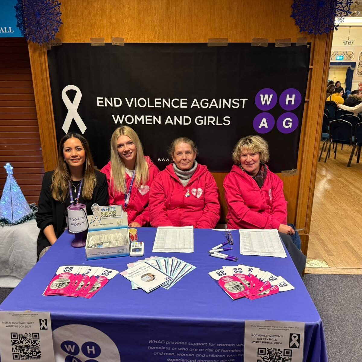 group of charity volunteers sat around an exhibition stall