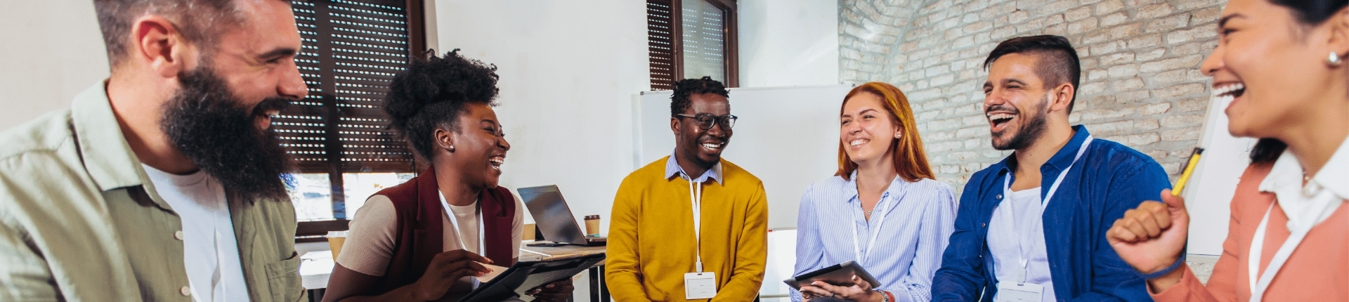 Board Recruitment Blog Six Solutions to Six Governance Challengeser (1920 x 430 px) 6 multi racial people sitting in a line and smilinh