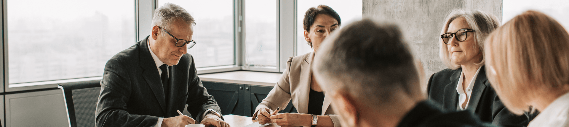 Good Merger Guide 2 of 7 Challenges & Barriers website banner 5 people in a meeting