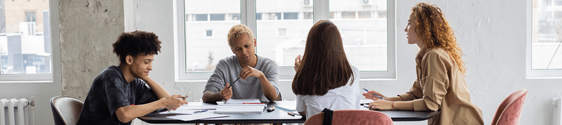 4 people sitting round a table having a discussion. Good Merger Guide 6 of 7 Due Diligence website banner