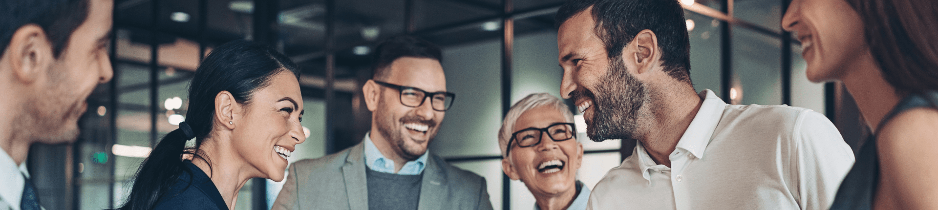 6 smiling people in a row head shots Good Merger Guide website banner 4 of 7 partners