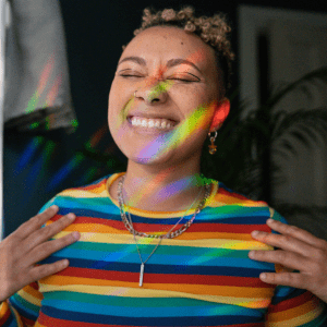 Diversity ethos website page round image. Portrait of nonbinary autistic person wearing a rainbow shirt
