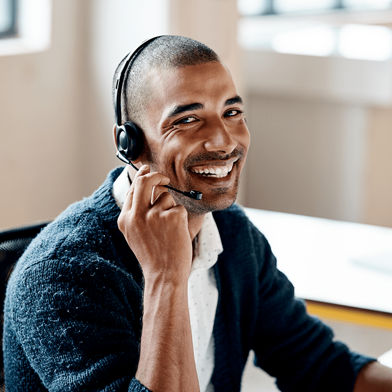 AdviceUK smiling Black man wearing a headset sitting at a computer