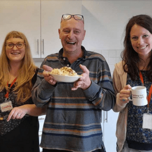 Evolve Housing + Support people in a kitchen holding food and mugs