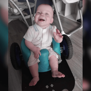 REMAP CEO website image a laughing baby in a mobility seat