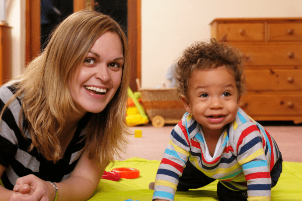 Childminder with a young child playing on a mat Coram PACEY case study 600 x 400