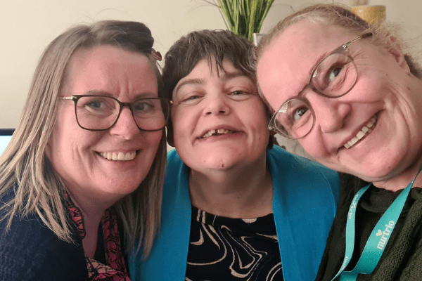 Nurtrio merger case study, faces of 3 people very close together, cheek to cheek