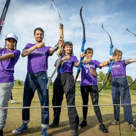 Grief Encounter day out 3 adults and a young boy enjoying archery