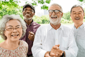 Age Uk Sutton, 4 older people smiling and looking happy