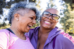 Age UK Sutton 2 older black women laughing together