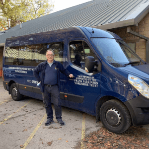 Frank Parkinson Yorkshire Trust image of a man standing by a navy blue minibus
